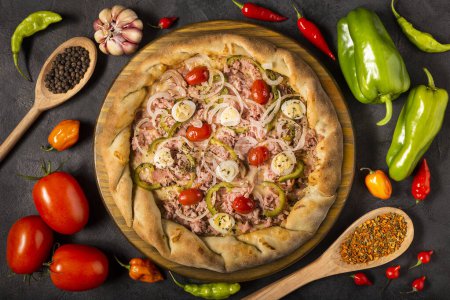Foto de Junta de pizza vacía en la mesa con ingredientes para cocinar. Tomates, varios pimientos, ajo y pimientos verdes. - Imagen libre de derechos