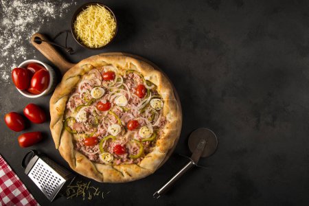 Téléchargez les photos : Pizza rustique sur fond sombre. - en image libre de droit