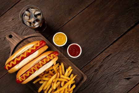 Hot dogs with french fries and soda. 