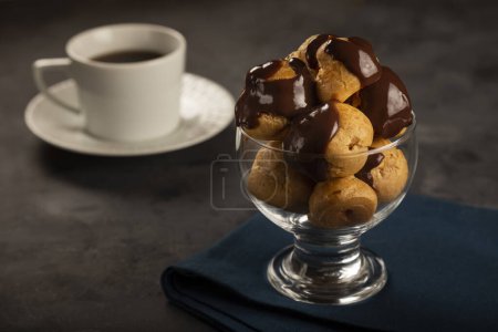 Photo for Delicious profiteroles with coffee on the table. - Royalty Free Image