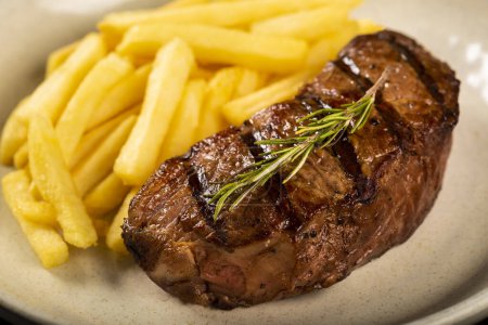 Téléchargez les photos : Plat avec steak grillé et frites. - en image libre de droit