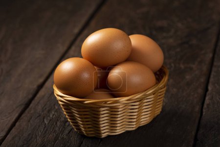 Photo for Basket with brown chicken eggs goes up the table. - Royalty Free Image