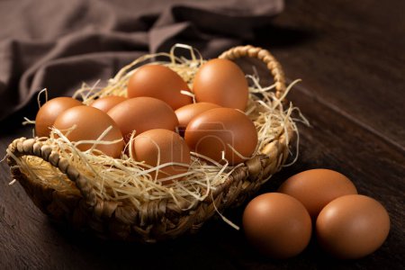Téléchargez les photos : Panier avec des œufs de poulet brun monte la table. - en image libre de droit