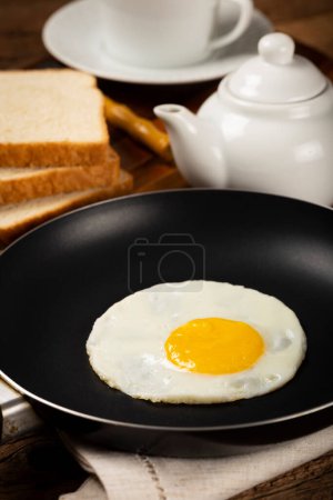 Desayuno con huevo frito en la sartén.