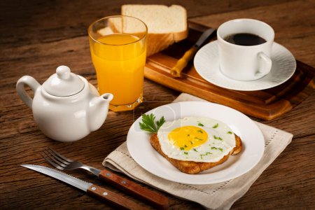 Foto de Desayuno con zumo, café y tostadas con huevo frito. - Imagen libre de derechos