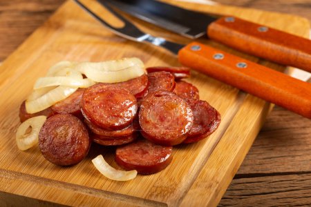 Photo for Sliced sausage with onion on wooden background. - Royalty Free Image