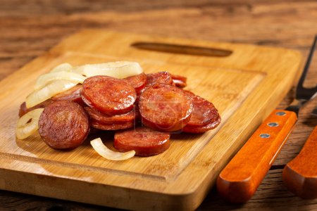 Photo for Sliced sausage with onion on wooden background. - Royalty Free Image