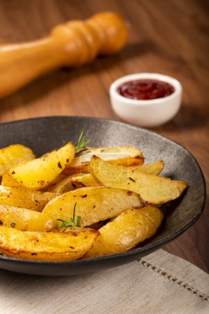 Téléchargez les photos : Pommes de terre rôties avec romarin dans l'assiette. - en image libre de droit