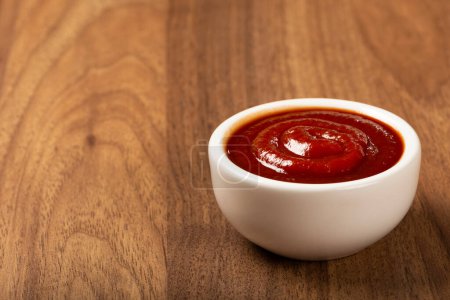 Téléchargez les photos : Ketchup tomate dans le ramequin sur fond en bois. - en image libre de droit