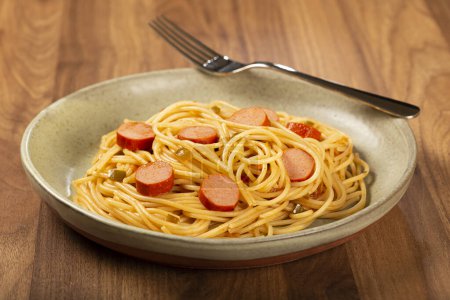 Foto de Pasta de espaguetis con salchichas en rodajas y salsa de tomate. - Imagen libre de derechos