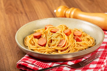 Spaghetti mit Wurstscheiben und Tomatensauce.