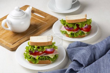 Foto de Sandwich natural. Sandwich con queso, jamón, lechuga, tomate y cebolla roja. - Imagen libre de derechos