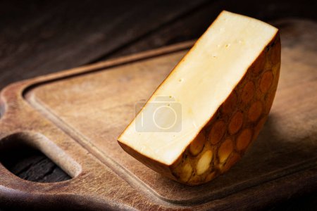 Smoked cheese. Piece of smoked cheese on the table.