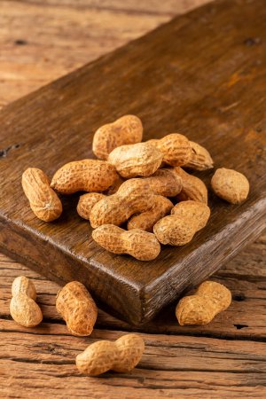 Dry peanut on the wooden background.