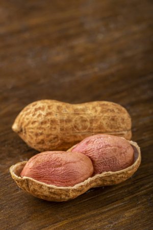 Dry peanut on the wooden background.