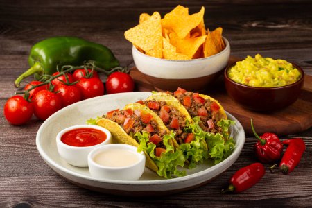 Photo for Mexican tacos with lettuce, beef and tomatoes. - Royalty Free Image