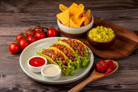 Photo for Mexican tacos with lettuce, beef and tomatoes. - Royalty Free Image