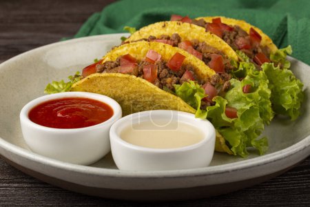 Mexican tacos with lettuce, beef and tomatoes.