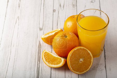 Vaso con zumo de naranja en la mesa.