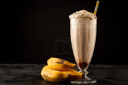 Photo for Vanilla milkshake with whipped cream, banana and chocolate syrup. - Royalty Free Image