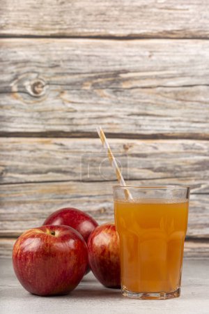 Foto de Jugo de manzana y manzanas rojas sobre la mesa. - Imagen libre de derechos