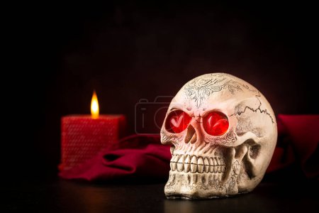Halloween-Katrinenschädel auf schwarzem Tisch vor dunklem Hintergrund.