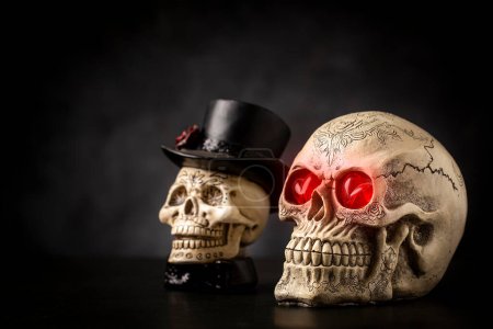 Halloween catrine skull on an black table in dark background.