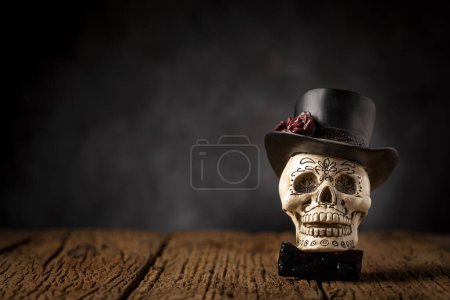 Halloween-Katrinenschädel auf einem alten Holztisch vor schwarzem Hintergrund.