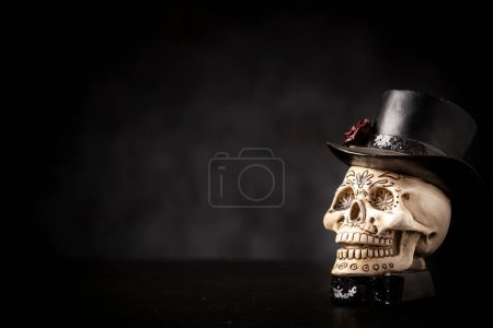 Photo for Halloween catrine skull on an black table in dark background. - Royalty Free Image