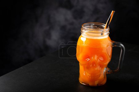 Halloween-Drink. Kürbisgetränk im Totenkopf-Glas.