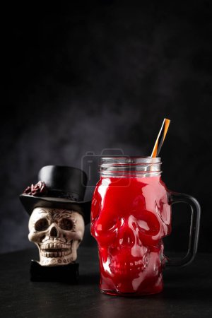 Halloween drink. Blood drink in skull glass. magic mug #709773338