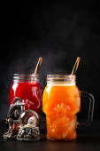 Halloween drink. Pumpkin drink and blood drink in skull glass. hoodie #709773386
