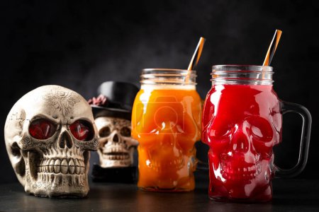 Un verre d'Halloween. Boisson à la citrouille et boisson de sang dans le verre du crâne.