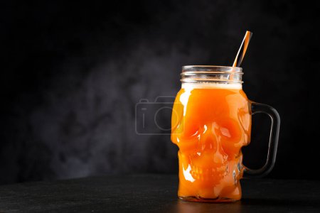 Foto de Bebida de Halloween. Bebida de calabaza en vaso de cráneo. - Imagen libre de derechos