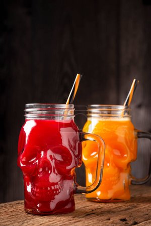 Foto de Bebida de Halloween. Bebida de calabaza y bebida de sangre en vaso de cráneo. - Imagen libre de derechos