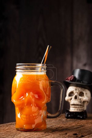 Bebida de Halloween. Bebida de calabaza en vaso de cráneo.