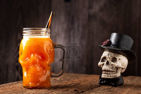 Foto de Bebida de Halloween. Bebida de calabaza en vaso de cráneo. - Imagen libre de derechos