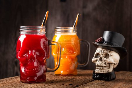 Un verre d'Halloween. Boisson à la citrouille et boisson de sang dans le verre du crâne.