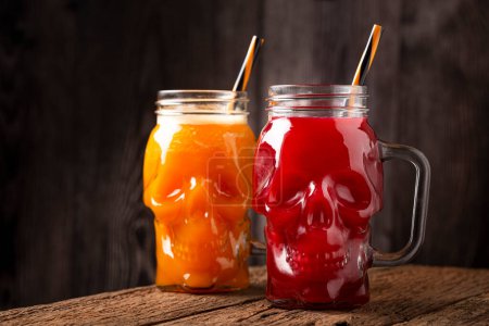 Foto de Bebida de Halloween. Bebida de calabaza y bebida de sangre en vaso de cráneo. - Imagen libre de derechos
