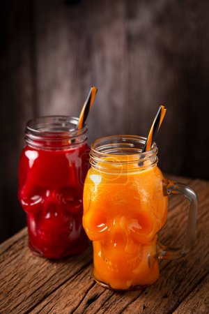 Photo for Halloween drink. Pumpkin drink and blood drink in skull glass. - Royalty Free Image