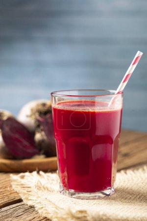 Photo for Red beet juice in a glass cup on the wooden table. - Royalty Free Image