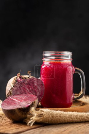 Téléchargez les photos : Jus de betterave rouge dans une tasse en verre sur la table en bois. - en image libre de droit