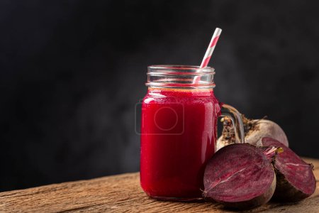 Photo for Red beet juice in a glass cup on the wooden table. - Royalty Free Image