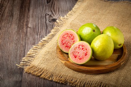 Photo for Fresh sliced guavas on the wooden table. - Royalty Free Image