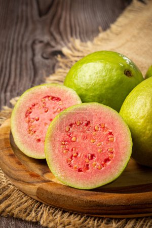 Photo for Fresh sliced guavas on the wooden table. - Royalty Free Image