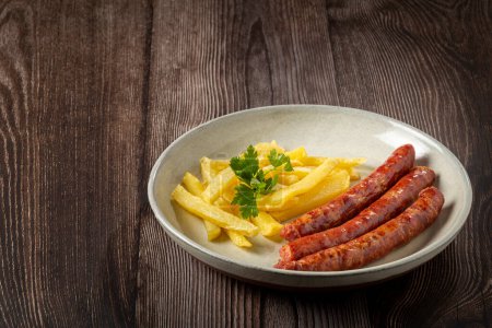 Photo for Grilled German sausage with french fries. - Royalty Free Image