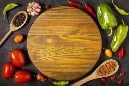 Photo for Empty pizza  board on the table with Ingredients for cooking. Tomatoes, various peppers, garlic and green peppers. - Royalty Free Image