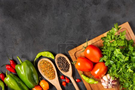 Ingrédients pour cuisiner avec des tomates, divers poivrons, ail et poivrons verts.