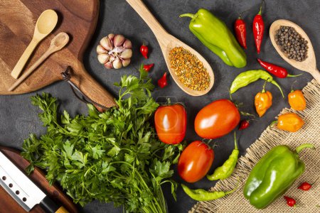 Foto de Ingredientes para cocinar con tomates, varios pimientos, ajo y pimientos verdes. - Imagen libre de derechos