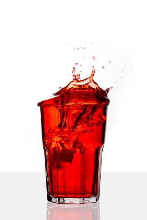 Foto de Bebida roja salpicada en aislado sobre fondo blanco. - Imagen libre de derechos